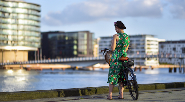 Kvinde med cykel ved havnen i København 